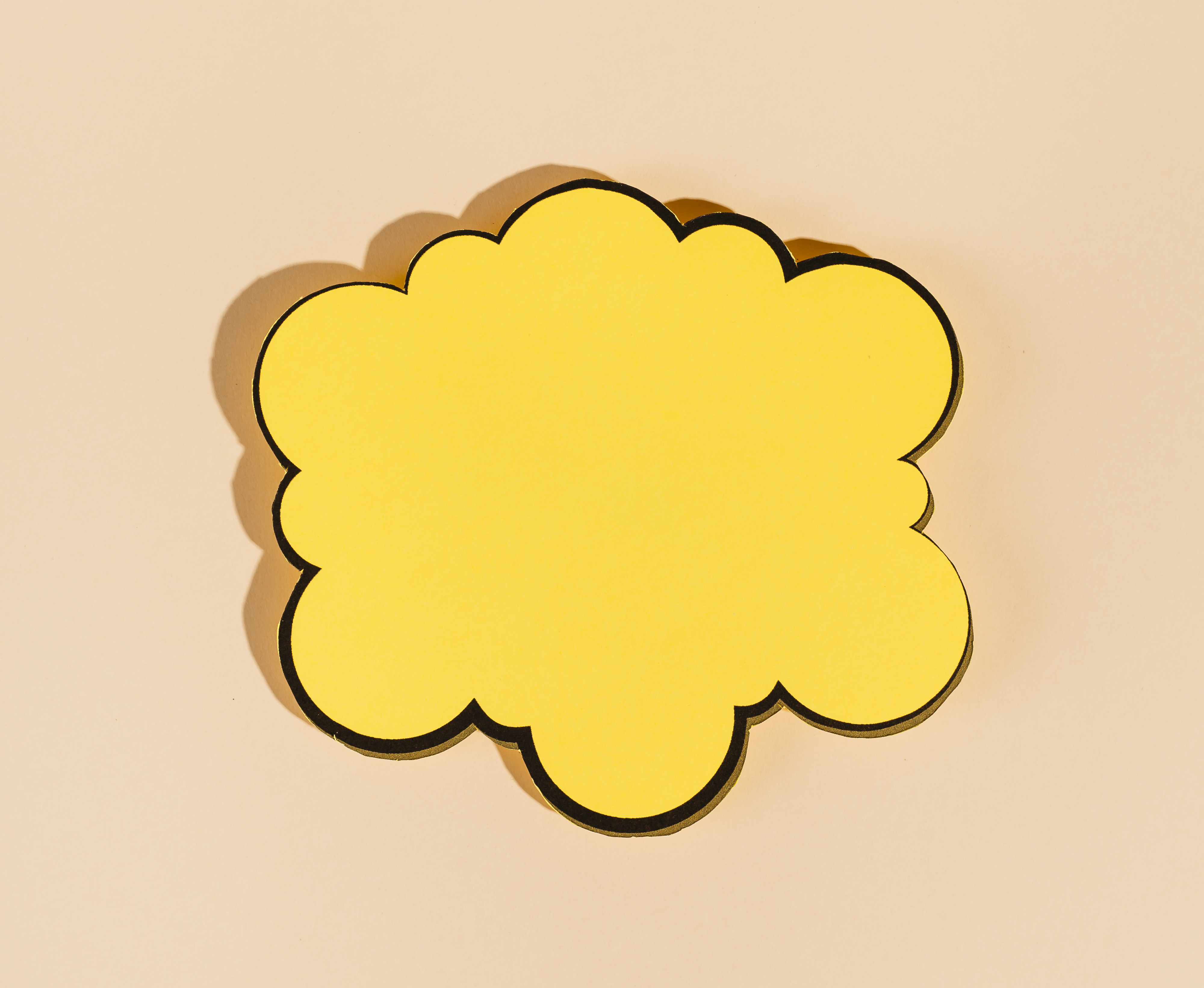 Yellow speech bubble cut out on a beige background